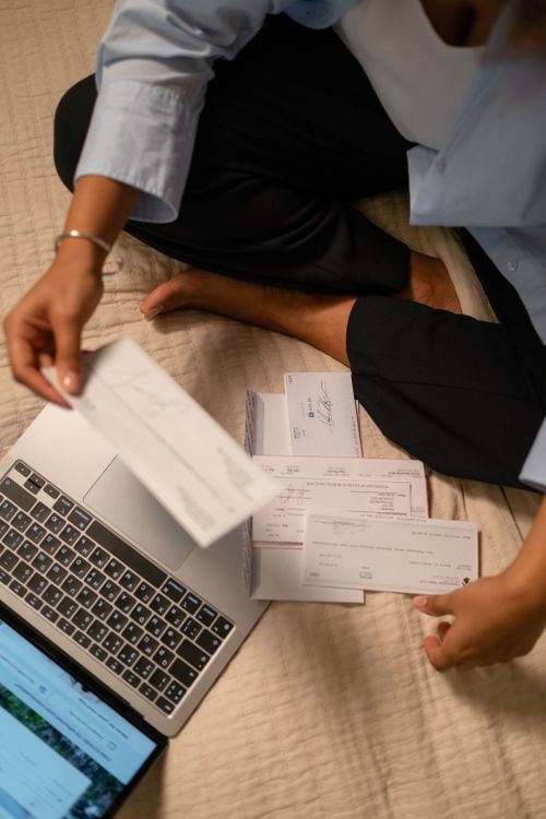 Hände halten ein Laptop, während Kontobewegungen geprüft werden